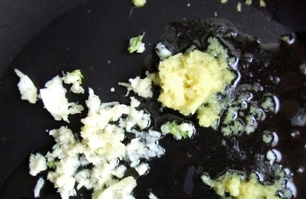 1. Этап. Креветки с грибами: Влейте на сковороду каноловое масло, добавьте чеснок и имбирь. Обжаривайте на медленном огне около 20 минут, помешивая.