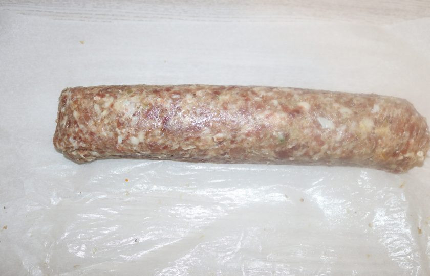 1. Этап. Мясной рулет с ананасами: Аккуратно сверните рулет, приподнимая край пергамента и накрывая начинку мясным фаршем.