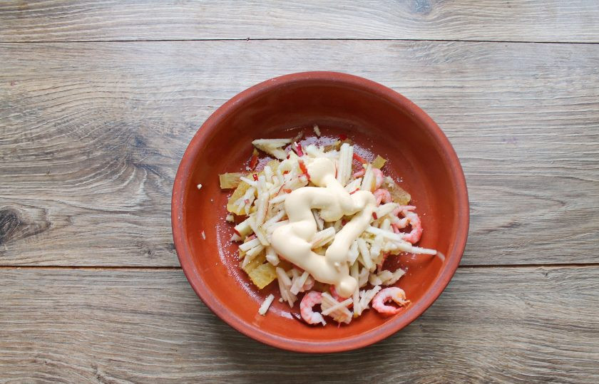 1. Этап. Салат с креветками, яблоком и ананасом: Салат посолите, добавьте майонез, перемешанный с одной ложкой сиропа от ананаса, и перемешайте. Разложите салат и украсьте зеленью.