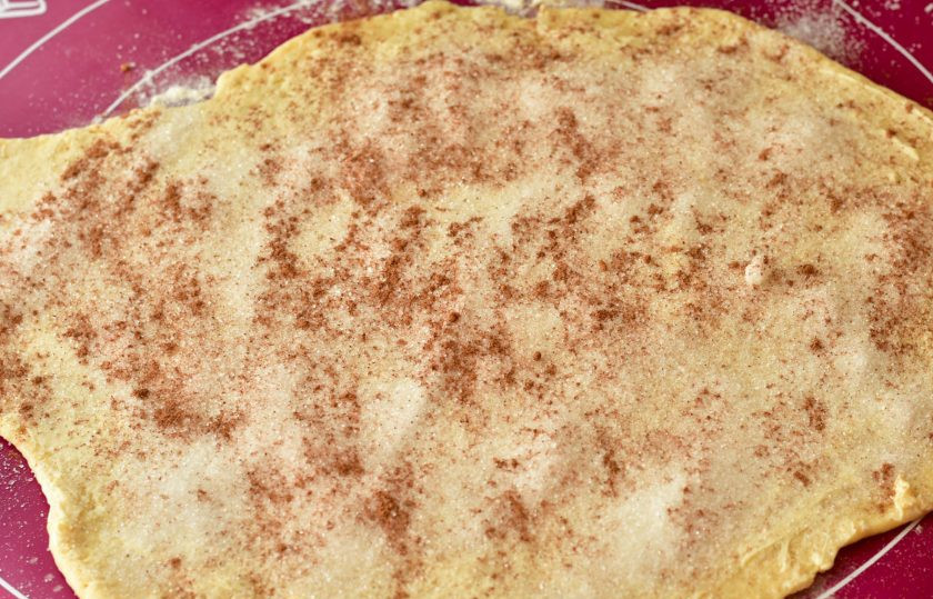 1. Этап. Печенье на кефире с корицей: Раскатайте тесто в пласт. Смажьте его оставшимся сливочным маслом, посыпьте сахаром и корицей.