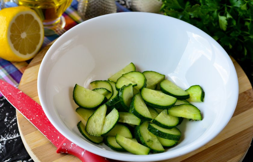 1. Этап. Салат с консервированным тунцом, яйцом и огурцом: Вымойте и нарежьте огурцы. Сложите в миску.