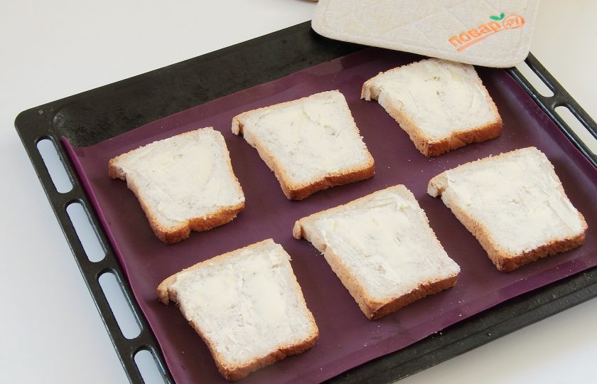 1. Этап. Тосты с яйцами Приятный завтрак: Смажьте хлеб с одной стороны маслом и выложите на противень.