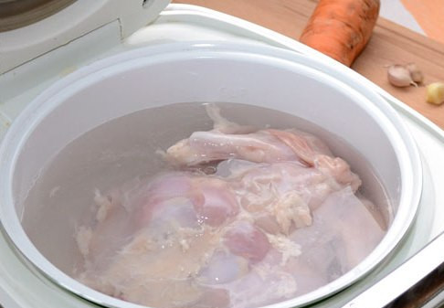 1. Этап. Заливное из курицы в мультиварке: Первым делом нам нужно избавиться от ненужного холестерина, поэтому мы полностью снимаем с куриной тушки кожу и удаляем жир. Промываем курицу под проточной водой и целиком помещаем ее в чашу мультиварки. Вливаем в чашу максимальное допустимое количество водички и включаем режим 