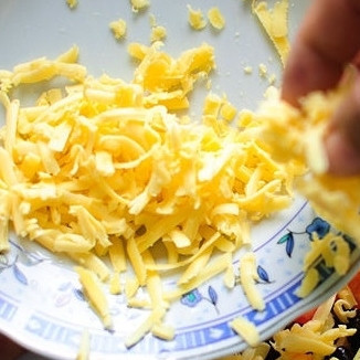 1. Этап. Салат Тако: 6. Добавьте тертый сыр в каждую тарелку.