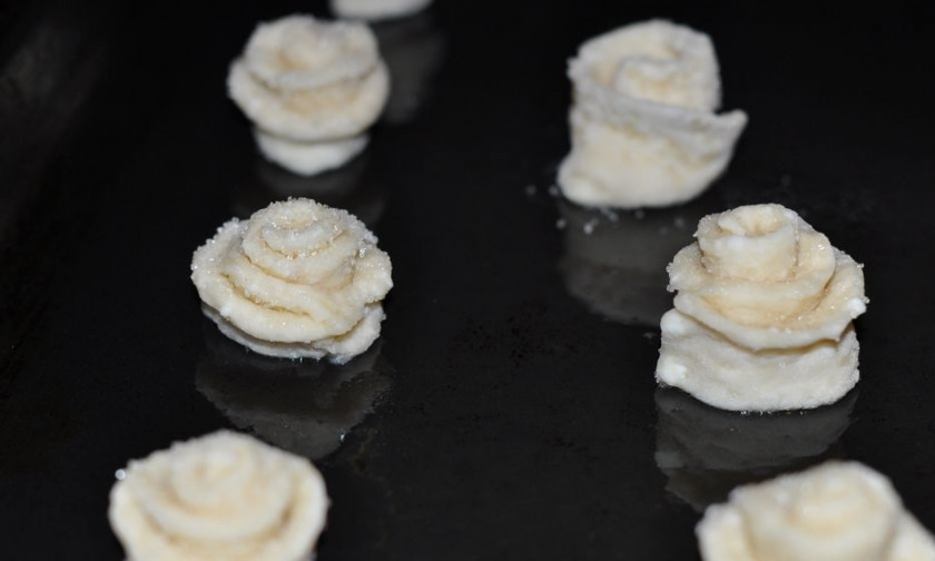 1. Этап. Низкокалорийное творожное тесто: Сверните каждую полоску в трубочку, разрежьте трубочку поперек, придайте ей форму цветка. Противень застелите пергаментом, духовку разогрейте до 180 градусов, отправьте печенье выпекаться на 20 минут.