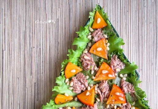 1. Этап. Новогодний салат Тунец и хурма: Посыпьте кедровыми орешками, поперчите и полейте салат заправкой.