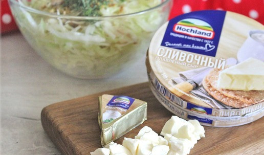 1. Этап. Киш «Осень»: Ломтики сливочного плавленого сыра ТМ Hochland освободить от фольги, нарезать небольшими кусочками, добавить в чашку с капустной начинкой.