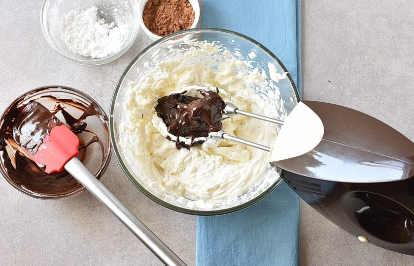 1. Этап. Шоколадный Чизкейк: Темный шоколад растопите. Удобно это сделать с помощью микроволновки. Прогревайте шоколад короткими импульсами по 10 секунд, перемешивая после нагрева. Обычно хватает 20-25 секунд на стандартную плитку. Влейте шоколад в крем-чиз и взбейте все вместе.