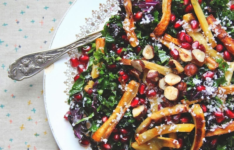 1. Этап. Салат Праздник: Теперь соберем салат: выложим на большое плоское блюдо капусту и сбрызнем растительным маслом, посолим. Дальше выкладываем пастернак, присыпаем зернами граната. Сверху кладем дробленые лесные орехи, присыпаем тертым пармезаном и перцем по вкусу. Сбрызгиваем все винным уксусом.