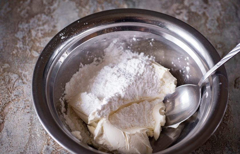 1. Этап. Шоколадный чизкейк с выпечкой: В просторную миску выложите весь сливочный сыр, добавьте сахарную пудру. Перемешайте эти ингредиенты ложкой до получения однородной массы, не используйте ни в коем случае миксер.