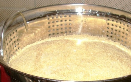 1. Этап. Рецепт кускуса по-арабски: Затем установите верхнюю часть кастрюли. Выложите в неё кускус. Добавьте к нему масло и немного томатной пасты.