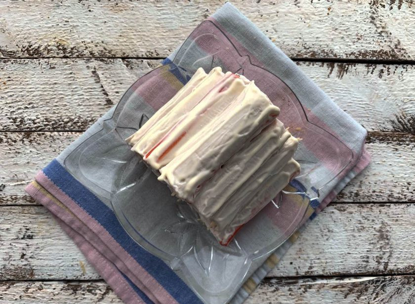 1. Этап. Салат Избушка из крабовых палочек: Смажьте пирамиду со внешней стороны майонезом.