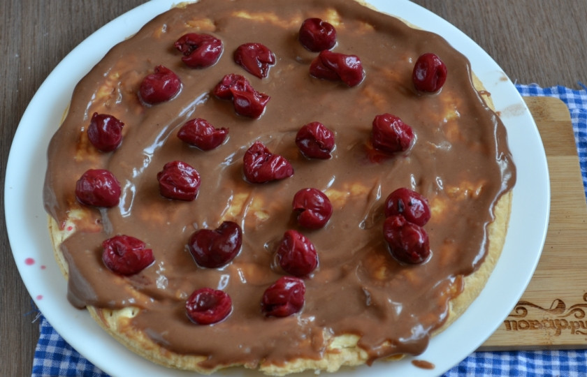 1. Этап. Шоколадный торт с вишней: Начинаем собирать торт. Первый корж положите на плоскую тарелку, обильно смажьте кремом и выложите вишню. Желательно использовать карамелизированную вишню и консервированную с сахаром.