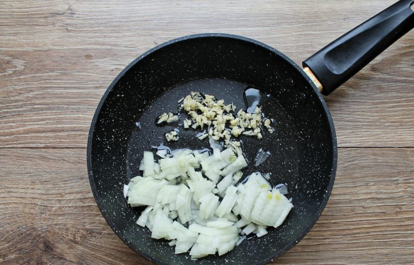 1. Этап. Томатный суп с кинзой: Репчатый лук порежьте, чеснок очистите и мелко порежьте. В сковороду налейте растительное масло и разогрейте, добавьте овощи и обжаривайте на среднем огне в течение 6 минут.