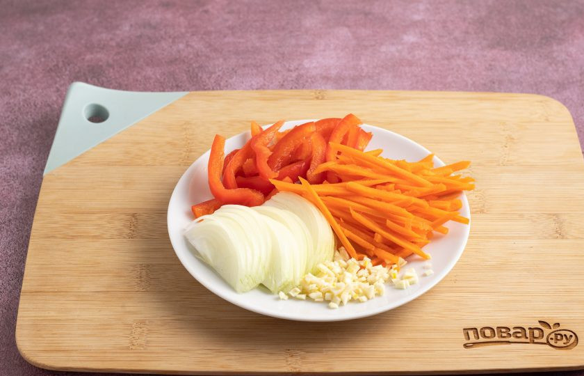 1. Этап. Древесные грибы по-корейски: Репчатый лук нарежьте перьями, а морковь натрите на терке для моркови по-корейски. Болгарский перец порежьте соломкой, а чеснок очистите и измельчите.