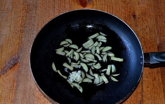 1. Этап. Салат с фунчозой и баклажанами: В сковороду к баклажанам добавьте пропущенный через пресс чеснок.