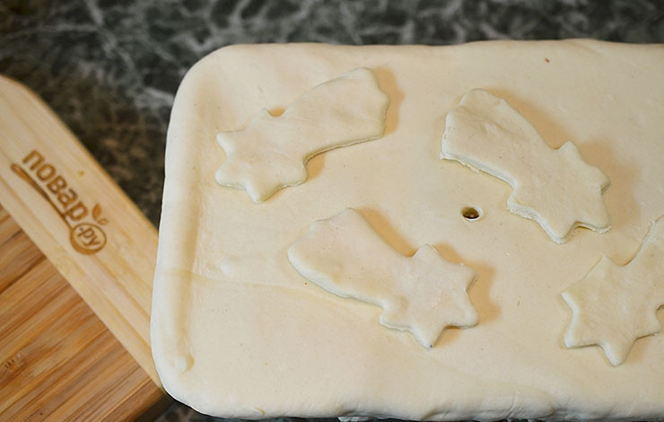 1. Этап. Пирог с рыбой и луком в горчичном соусе: Тесто разморозьте и раскатайте. Выложите сверху на форму, хорошо защипните края. Лишнее срежьте, вырежьте какие-нибудь фигурки для украшения, которые положите на верх пирога. В центре сделайте дырочку и смажьте верх пирога желтком.