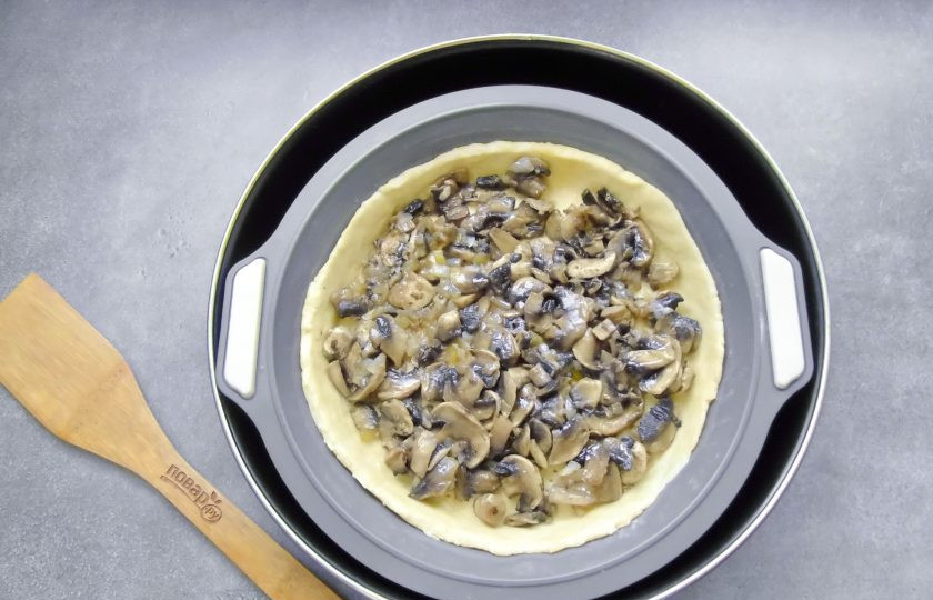 1. Этап. Грибной тарт: Достаньте тесто из холодильника, раскатайте и выложите в форму, образуя бортики. Наколите вилкой и распределите по тесту грибную начинку.