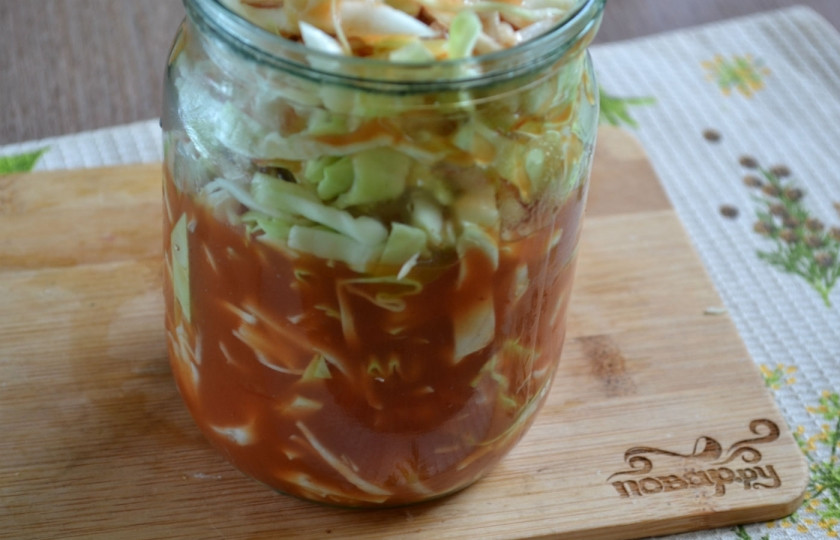 1. Этап. Капуста, маринованная в томате, на зиму: В подготовленные стерилизованные банки разложите нашинкованную капусту. Слегка утрамбуйте рукой или просто встряхните банку. Залейте горячим томатным соком на 2/3 банки.