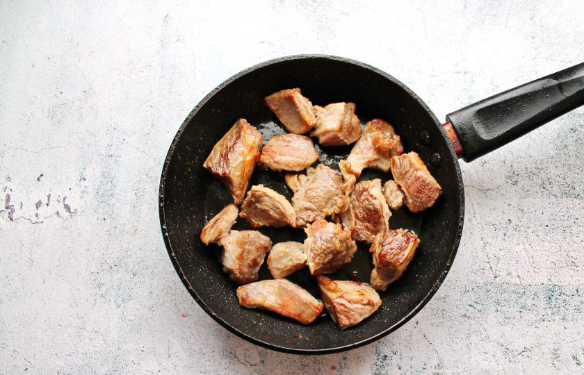 1. Этап. Томленая пашина: Мясо вымойте, обсушите и порежьте на кусочки. Добавьте специи, перемешайте и оставьте на один час. Затем обжарьте мясо в горячей сковороде с маслом на сильном огне до золотистой корочки со всех сторон.