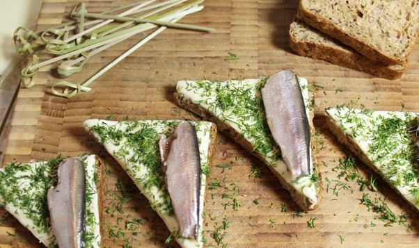 1. Этап. Бутерброды с килькой: Выкладываем на каждый треугольник хлеба по одной рыбке.