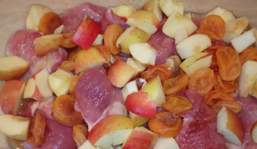 1. Этап. Индейка кусочками, запеченная в духовке: Промываем яблоки и курагу. Яблоки очищаем от сердцевины и семечек, нарезаем кубиками. Добавляем все в форму для запекания.