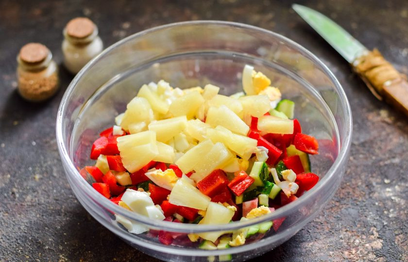 1. Этап. Салат с ананасами и колбасой: Консервированные ананасы нарежьте небольшими кубиками и добавьте в салат.