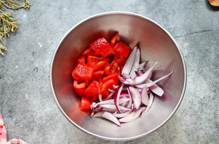 1. Этап. Овощное рагу с брокколи и баклажанами: Красный лук порежьте средними дольками, болгарский перец крупными кусками и выложите овощи в миску.
