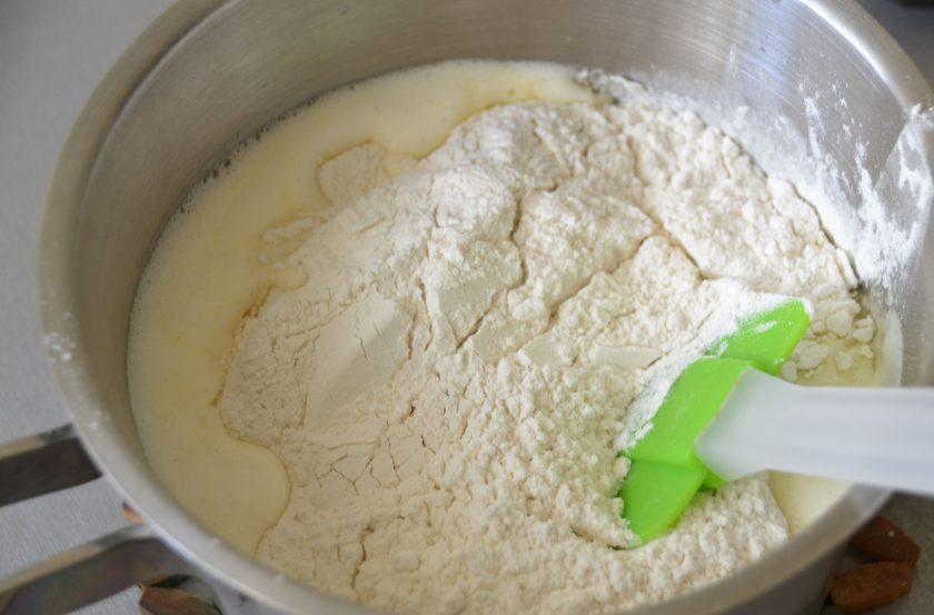 1. Этап. Глазурь для эклеров: Всыпьте в нагретое молоко сразу всю муку, интенсивно размешайте, до тех пор, пока тесто не станет отставать от стенок сотейника.