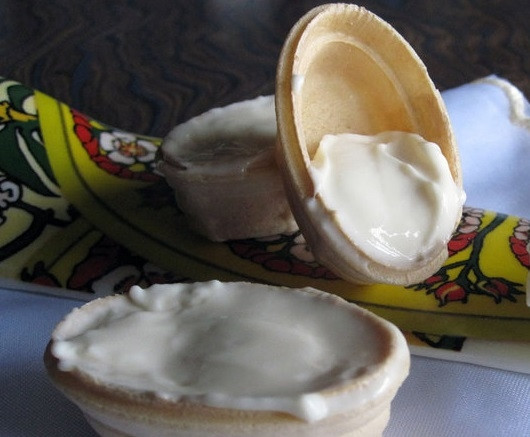 1. Этап. Вафельные тарталетки: Возьмите вафельные тарталетки. Заполните их сливочным сыром. Сыр можете использовать как классический, так и с добавлением различных трав.