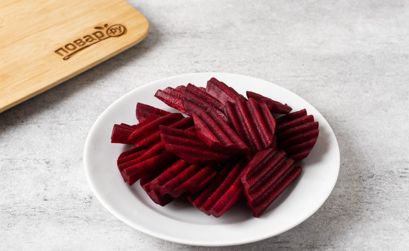 1. Этап. Огурцы маринованные со свеклой на зиму: Свеклу помойте, очистите от кожуры и порежьте на ломтики средней толщины примерно 1-1,5 см.