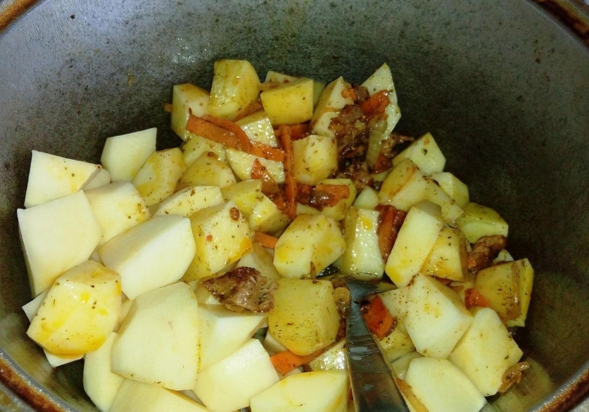 1. Этап. Жаркое по-домашнему из свинины с картошкой: 3. Тем временем чищу картошку и нарезаю ее кусочками, добавляю картошку в казан, перемешиваю.