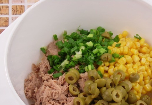 1. Этап. Рыбно-рисовый салат с кукурузой: Туда же отправить измельченный зеленый лук и нарезанные колечками оливки.