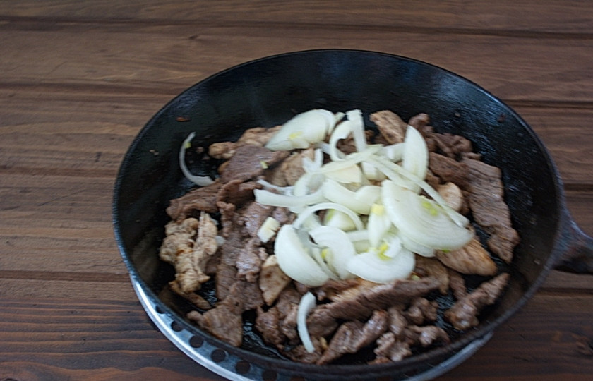 1. Этап. Свинина с картошкой на сковороде: На сковороду к мясу выкладываем нарезанный лук.