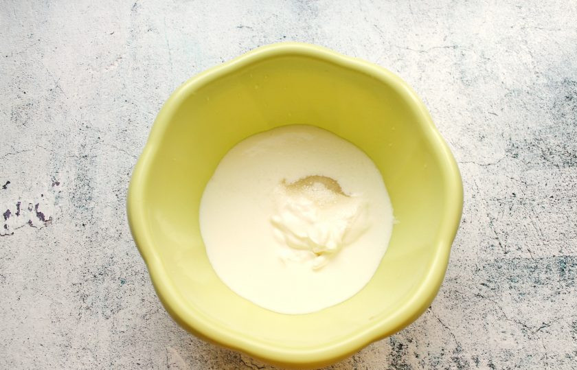 1. Этап. Пирожки на кефире и сметане: В миску влейте теплый кефир и добавьте сметану.