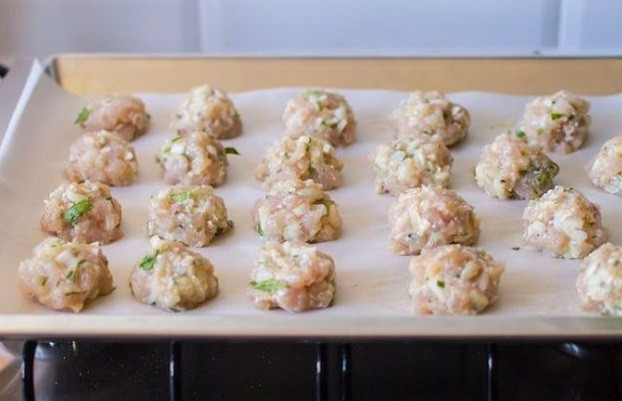 1. Этап. Куриные шарики в сливочном соусе с зеленым горошком: 4. Сформируйте небольшие шарики, выложите их на противень, застеленный пергаментом. Отправьте в разогретую до 200 градусов духовку минут на 20-25.