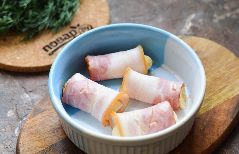 1. Этап. Бананы в беконе: Переложите заготовку рулетиков в форму для духовки. Отправьте в разогретую до 180 градусов духовку, готовьте 15 минут.