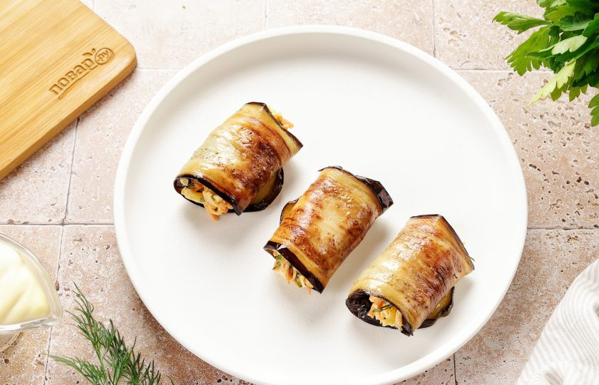 1. Этап. Рулет из баклажанов с сыром и корейской морковью: Сверните пластины баклажанов с начинкой рулетиком.