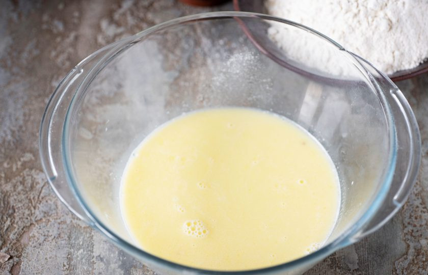 1. Этап. Корейские пончики: В просторную миску залейте теплое молоко, добавьте сахар и растопленное сливочное масло. Перемешайте все венчиком.