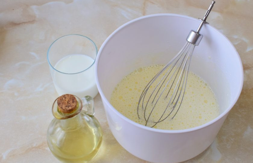 1. Этап. Кекс с вишней в микроволновке: К взбитым яйцам вмешайте молоко и растительное масло.