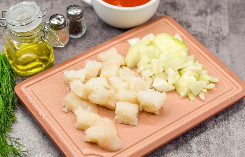 1. Этап. Паста с филе минтая: Филе рыбы просмотрите, чтобы не было костей. Нарежьте филе небольшими кусочками. Также очистите лук, ополосните, просушите, нарежьте небольшими кубиками.