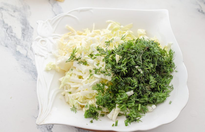 1. Этап. Заливной пирог с капустой и сыром: Капусту нашинкуйте тонкими полосками, укроп мелко нарежьте. Смешайте их, посолите и поперчите по вкусу.