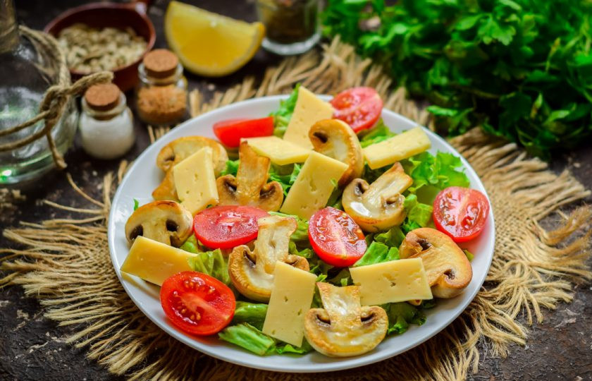 1. Этап. Зеленый салат с грибами: Твердый сыр нарежьте пластинами и выложите в салат.