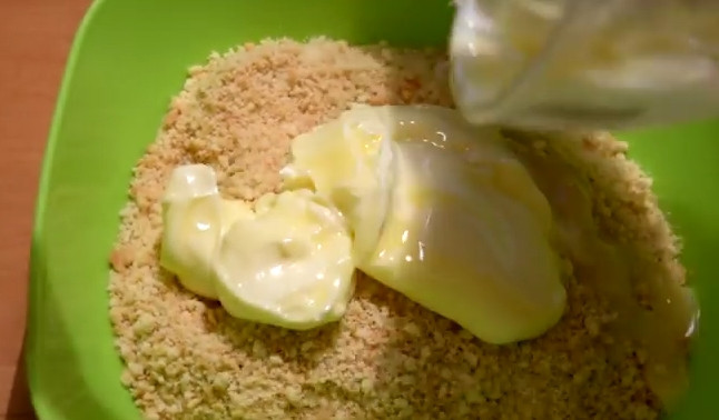 1. Этап. Творожный чизкейк со сгущенкой: 2. Сливочное масло растопите на водяной бане или в микроволновке. Добавьте к печенью и перемешайте, пока масса не начнет собираться в комок.