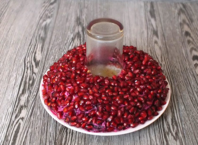 1. Этап. Салат Гранатовый браслет с черносливом и грецким орехом: Гранат очистите, извлеките гранатовые зерна и обсыпьте верх салата, слегка прижимая ладонями. Подготовленный салат поставьте в холодильник на 3-4 часа. Перед подачей достаньте и извлеките стакан.