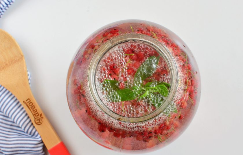 1. Этап. Компот из красной смородины на зиму: Залейте крутым кипятком банку. Прикройте крышкой. Поставьте в кастрюлю с теплой водой (на дно простелите салфетку) и стерилизуйте 10 минут с момента закипания.