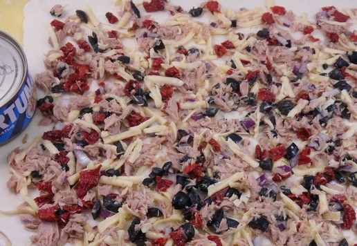 1. Этап. Пирог с тунцом и маслинами: Заранее размороженное тесто раскатать в тонкий пласт, 30х35 см. Ровным слоем выложить на него начинку.