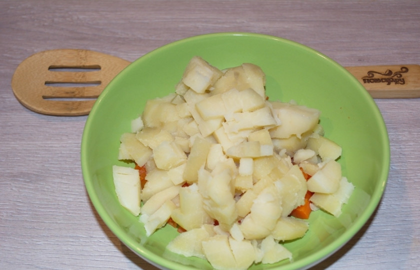 1. Этап. Салат Уральские самоцветы: Отварной картофель в мундире необходимо сначала очистить от кожуры. А затем уже можно нарезать кубиком. Добавляем нарезанный картофель в салатник.