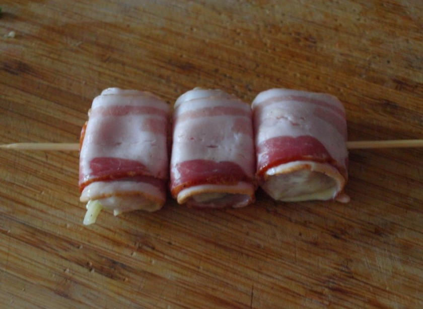 1. Этап. Куриный шашлык в сметане: 4. Заранее необходимо подготовить шпажки, на которых будет готовиться шашлык. Их нужно залить водой и оставить на 1-2 часа, - это предотвратит их горение во время приготовления. 3-4 кусочка филе аккуратно нанизан на шпажку так, чтобы закрепить свободный край полосочки бекона.