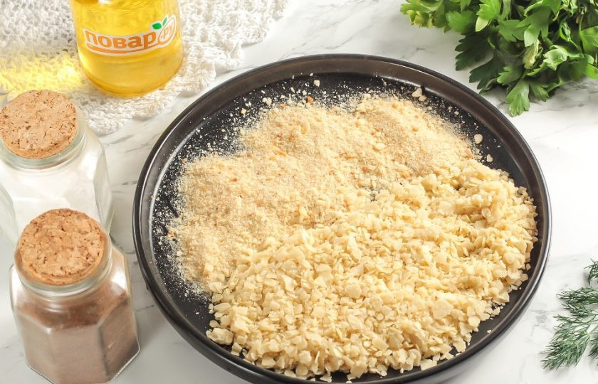 1. Этап. Наггетсы на сковороде: Чипсы разломите и измельчите. Перемешайте их на тарелке вместе с панировочными сухарями.